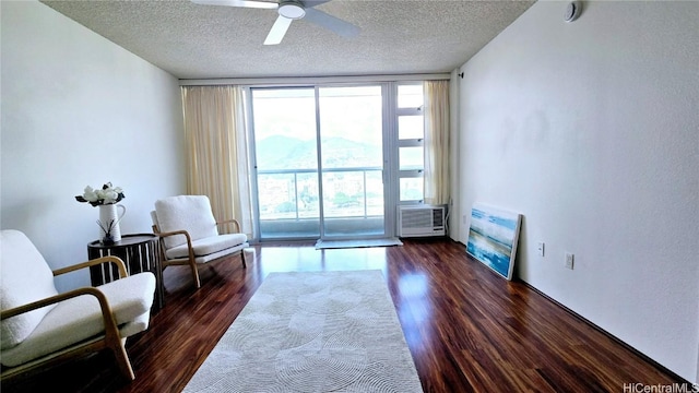 sitting room with floor to ceiling windows, dark hardwood / wood-style floors, ceiling fan, and a textured ceiling