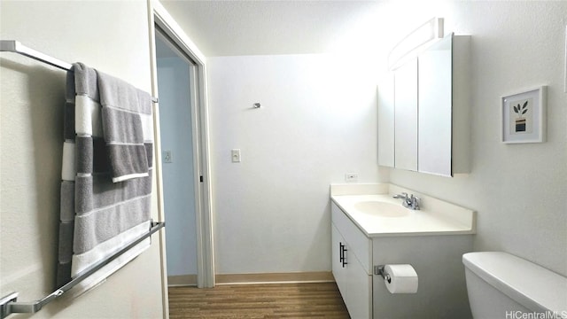 bathroom with vanity, wood-type flooring, and toilet