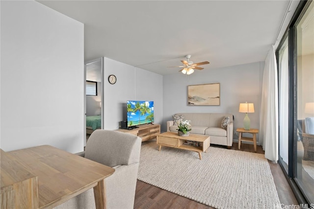 living room with dark wood-type flooring and ceiling fan