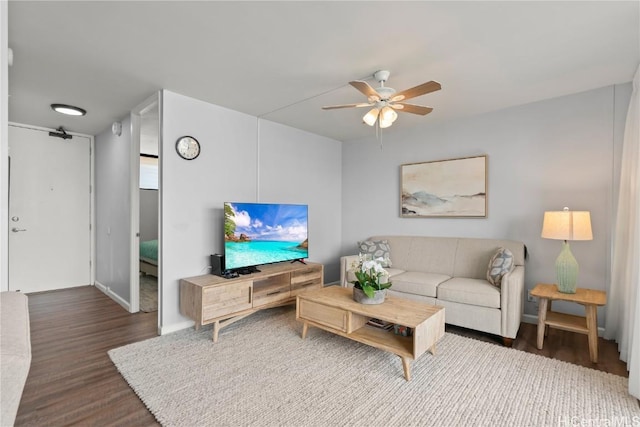 living room with ceiling fan and dark hardwood / wood-style floors