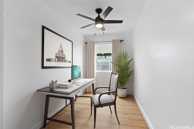 office featuring baseboards, a ceiling fan, and light wood-style floors