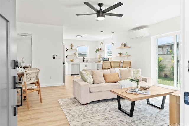 living room featuring a wall unit AC, light wood-style floors, ceiling fan, and baseboards