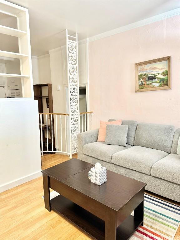 living room with crown molding and hardwood / wood-style flooring