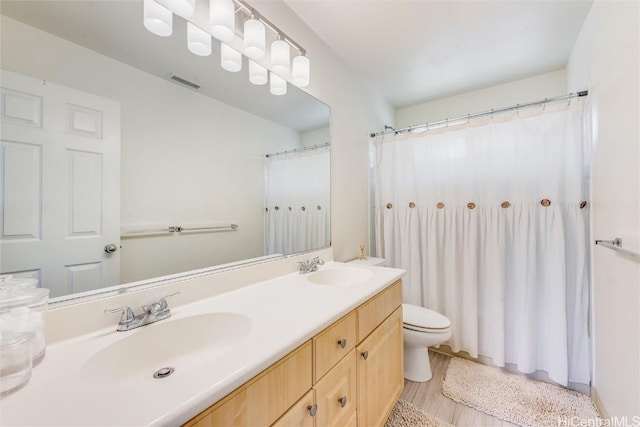 bathroom featuring vanity, hardwood / wood-style flooring, and toilet