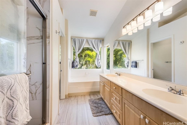 bathroom featuring independent shower and bath, vanity, and wood-type flooring