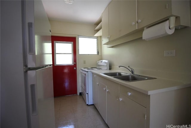 kitchen featuring white electric stove, white cabinetry, sink, and refrigerator