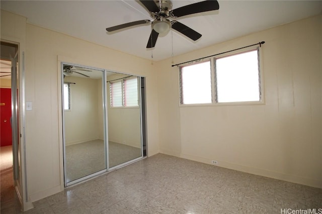 unfurnished bedroom featuring ceiling fan and a closet