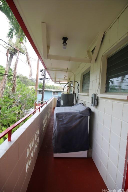 view of patio featuring gas water heater, a balcony, and a grill