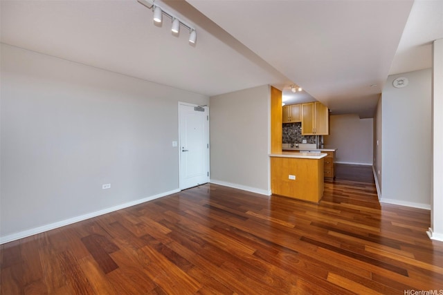1288 Kapiolani Blvd Unit I-1707, Honolulu, HI 96814 - unfurnished living room featuring dark wood finished floors, baseboards, and rail lighting