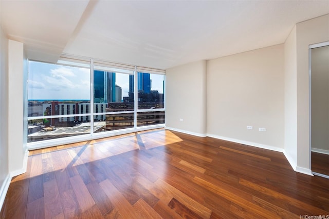 1288 Kapiolani Blvd Unit I-1707, Honolulu, HI 96814 - empty room featuring wood finished floors, a wall of windows, baseboards, and a city view