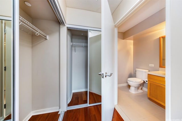 1288 Kapiolani Blvd Unit I-1707, Honolulu, HI 96814 - bathroom with vanity, a walk in closet, toilet, baseboards, and wood finished floors