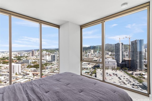 unfurnished bedroom with multiple windows, a view of city, and expansive windows