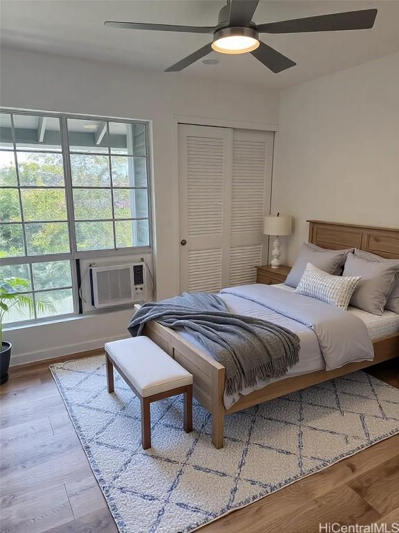 bedroom featuring ceiling fan, cooling unit, and wood finished floors