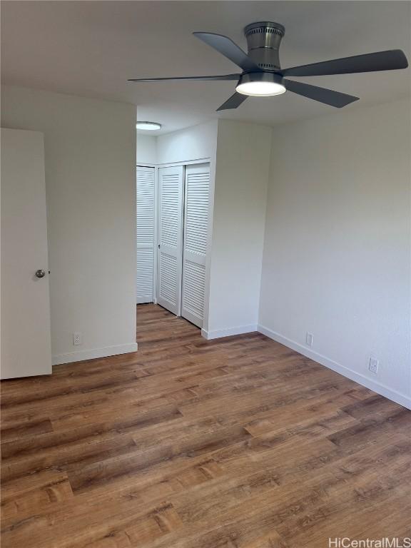 unfurnished room with ceiling fan, baseboards, and wood finished floors