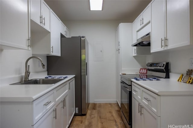 kitchen featuring under cabinet range hood, a sink, white cabinets, and electric stove