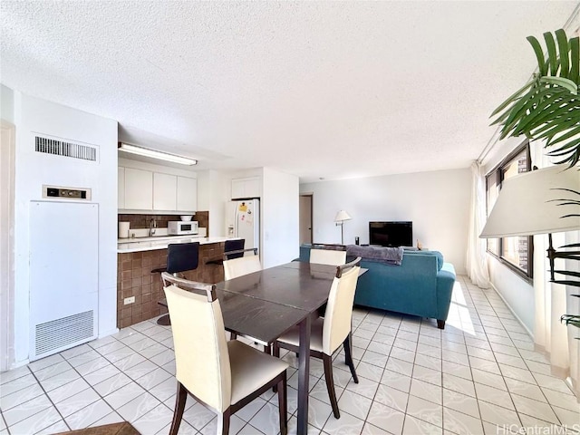 dining room featuring light tile patterned floors and a textured ceiling