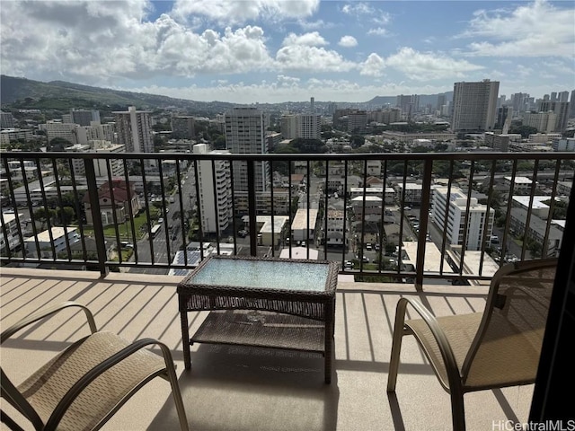 balcony featuring a mountain view and a city view