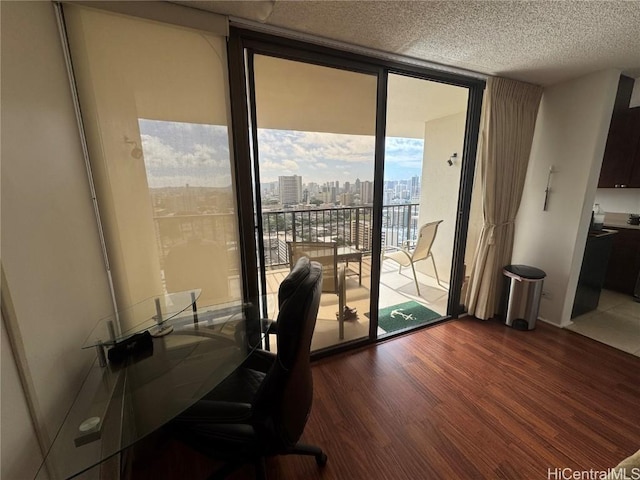 office area featuring a textured ceiling, a wall of windows, a city view, and wood finished floors