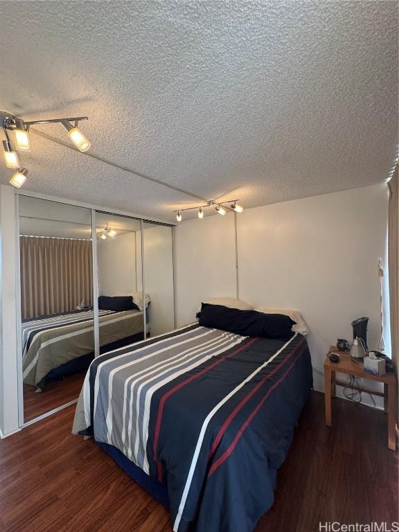 bedroom featuring dark wood finished floors and a textured ceiling