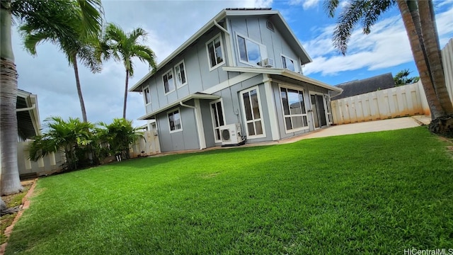 rear view of house featuring a yard and ac unit