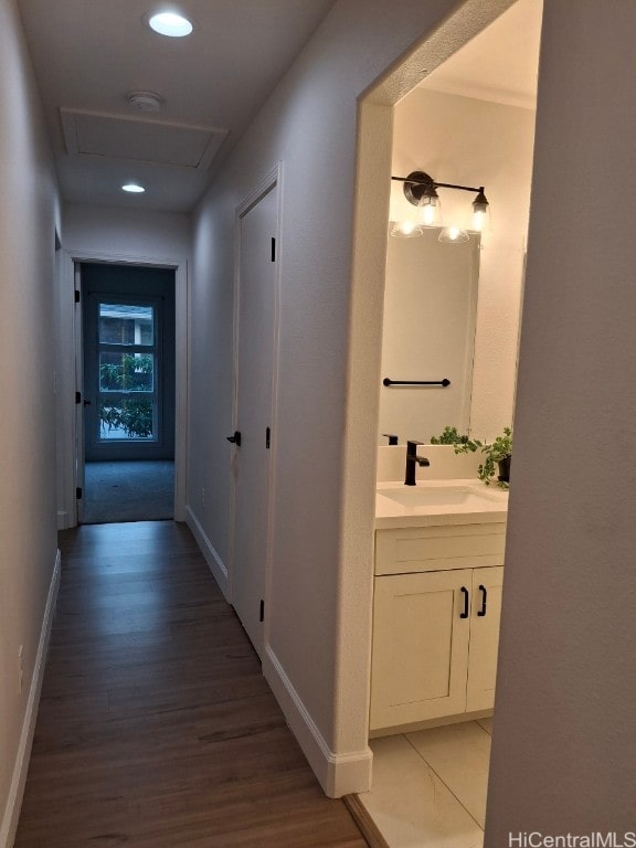 corridor featuring sink and light wood-type flooring