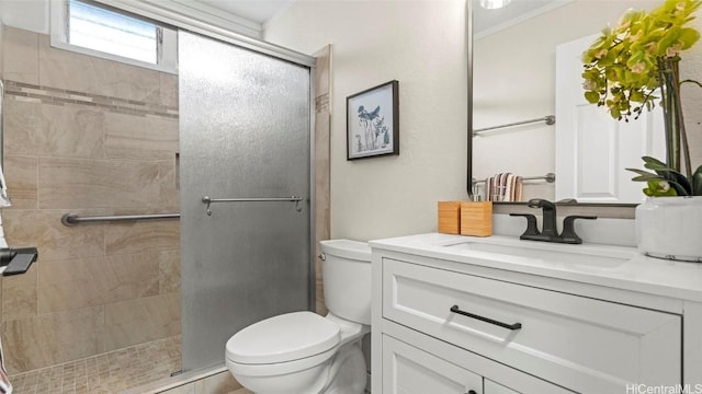 bathroom with crown molding, vanity, toilet, and a shower with shower door