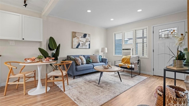 living room with crown molding and light wood-type flooring