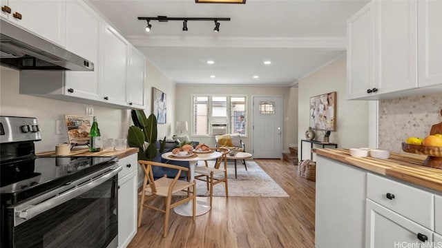 kitchen with white cabinetry, extractor fan, electric range, and butcher block counters