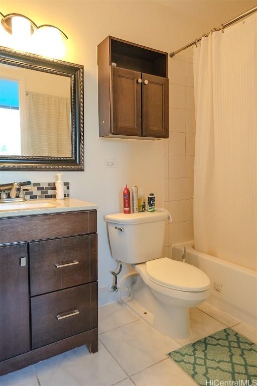 full bathroom featuring tile patterned floors, toilet, vanity, and shower / bathtub combination with curtain