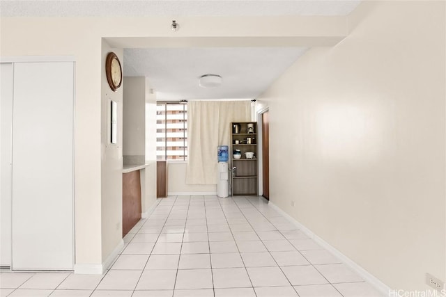 hall with baseboards and light tile patterned flooring