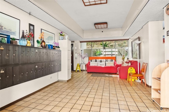 recreation room featuring baseboards, light tile patterned flooring, a raised ceiling, and mail area