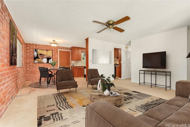 carpeted living room with ceiling fan, a textured ceiling, and brick wall