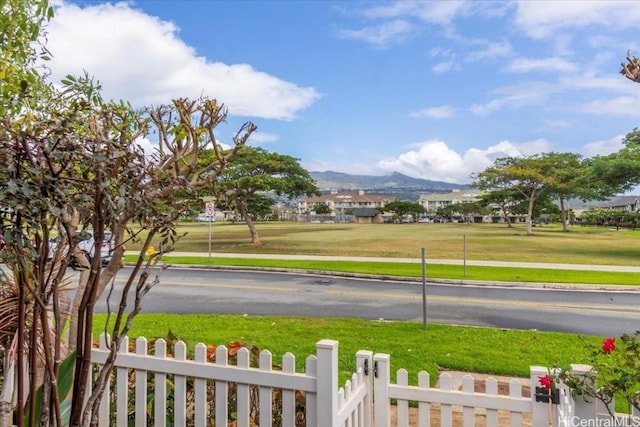 view of yard featuring a mountain view and fence