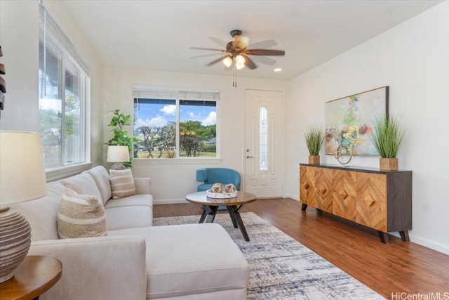 living area with recessed lighting, plenty of natural light, wood finished floors, and baseboards