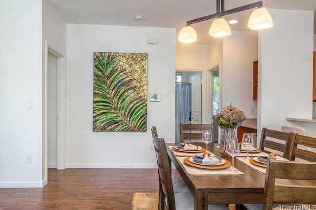 dining area featuring dark wood-type flooring and baseboards