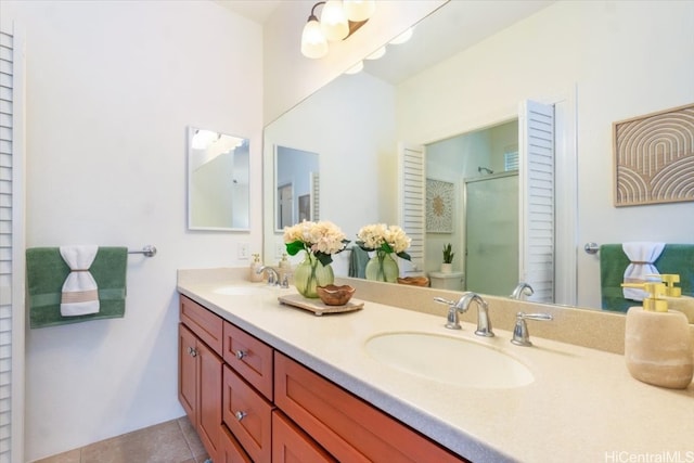 bathroom with tile patterned flooring, double vanity, a stall shower, and a sink