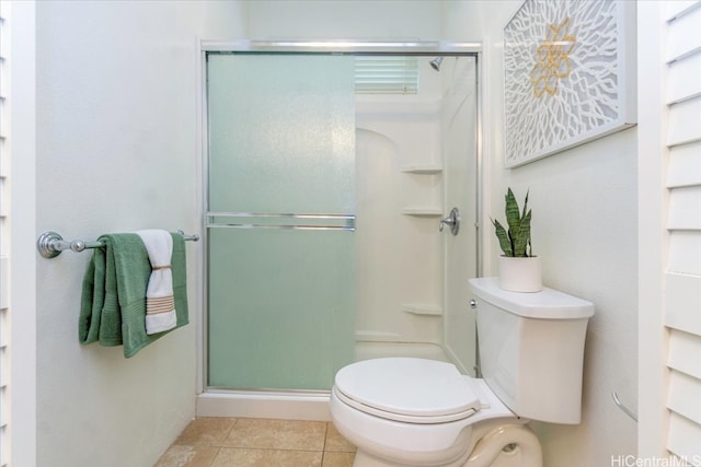 bathroom with tile patterned flooring, a shower stall, and toilet