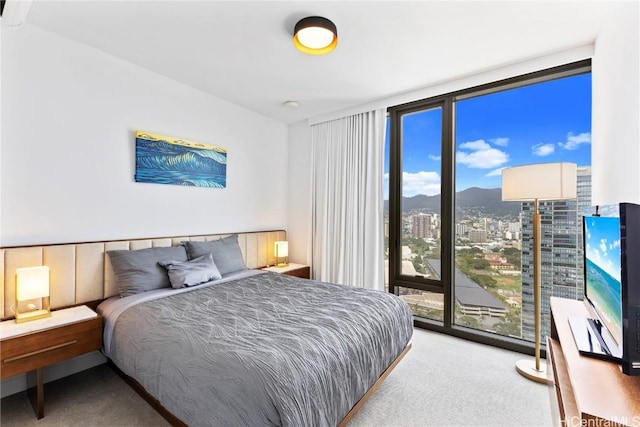 bedroom with a wall of windows, access to outside, and light colored carpet