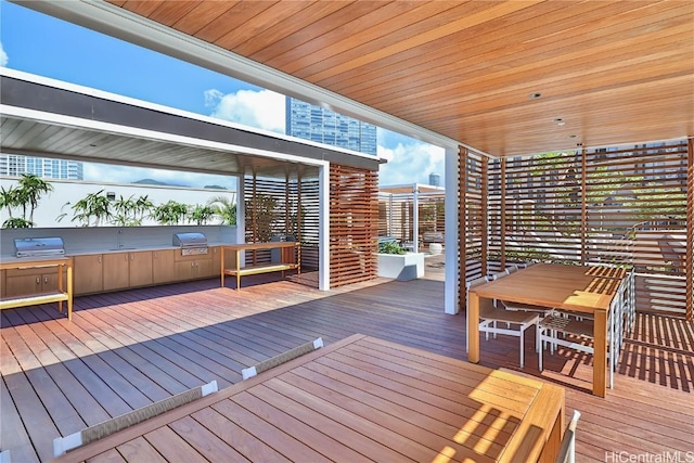 deck featuring outdoor dining area, grilling area, and an outdoor kitchen