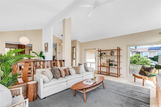 carpeted living room with ceiling fan and high vaulted ceiling