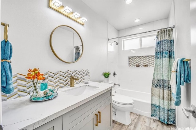 full bathroom featuring toilet, wood-type flooring, shower / tub combo with curtain, and vanity