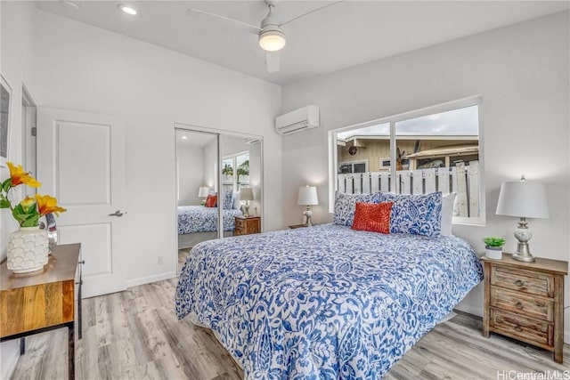 bedroom featuring an AC wall unit, a closet, ceiling fan, and light hardwood / wood-style flooring