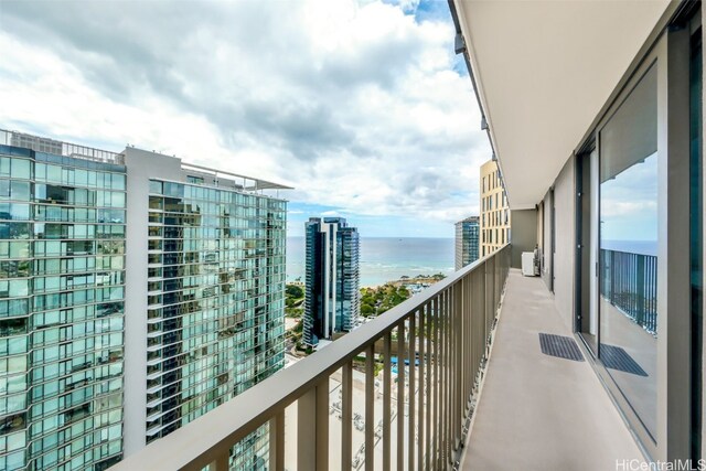 balcony with a water view and a view of city