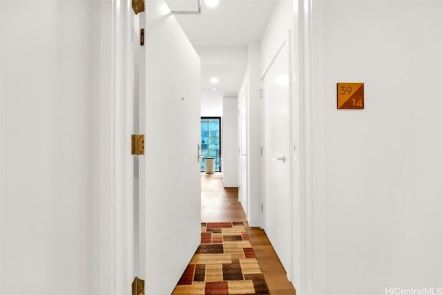 hall featuring wood finished floors and recessed lighting