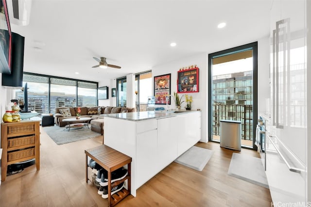 kitchen with a peninsula, light countertops, white cabinetry, and floor to ceiling windows