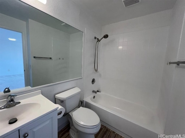 full bathroom featuring tiled shower / bath combo, vanity, wood-type flooring, and toilet