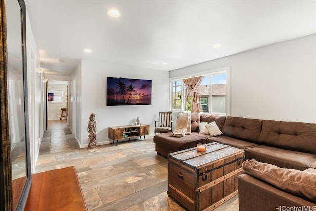 living room featuring baseboards, stone finish flooring, and recessed lighting