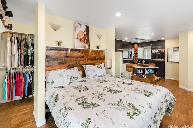 bedroom featuring baseboards, visible vents, wood finished floors, a closet, and recessed lighting