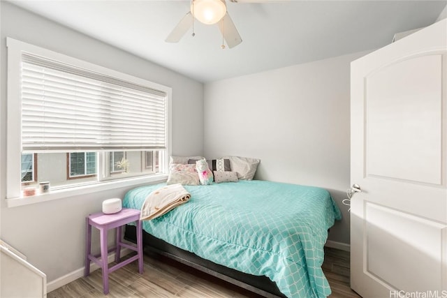 bedroom featuring wood finished floors, a ceiling fan, and baseboards