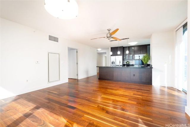 unfurnished living room with ceiling fan and dark hardwood / wood-style floors